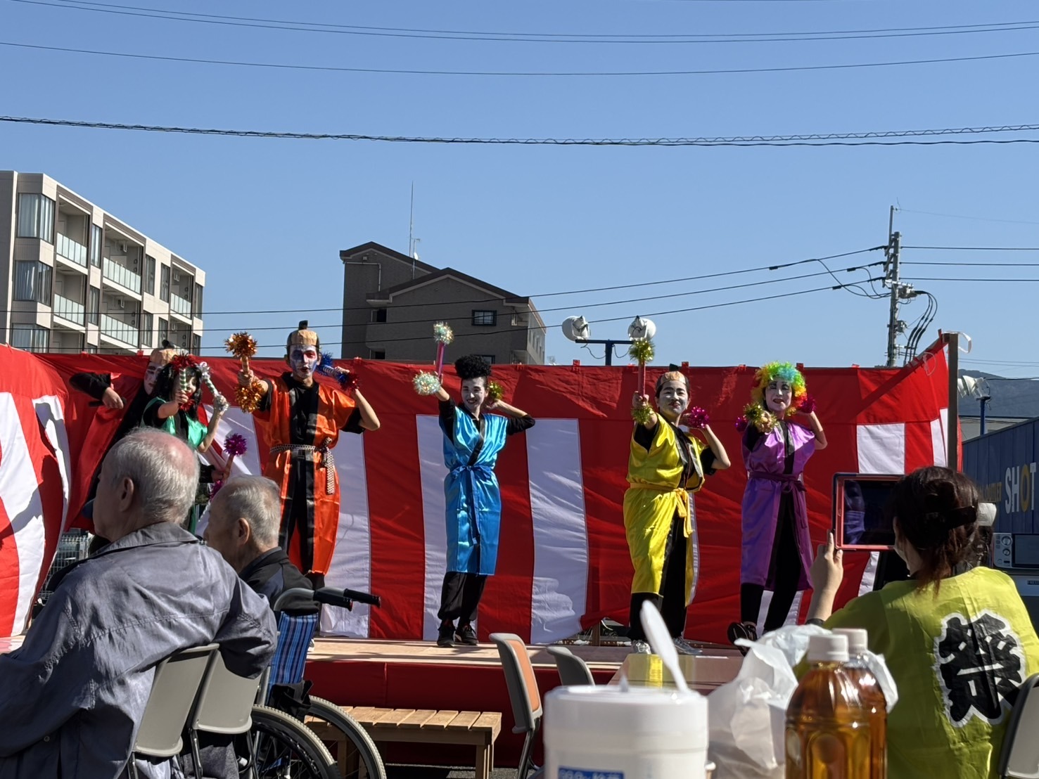 2025年の秋祭りで、ステージの出し物を楽しむ来場者と出演者