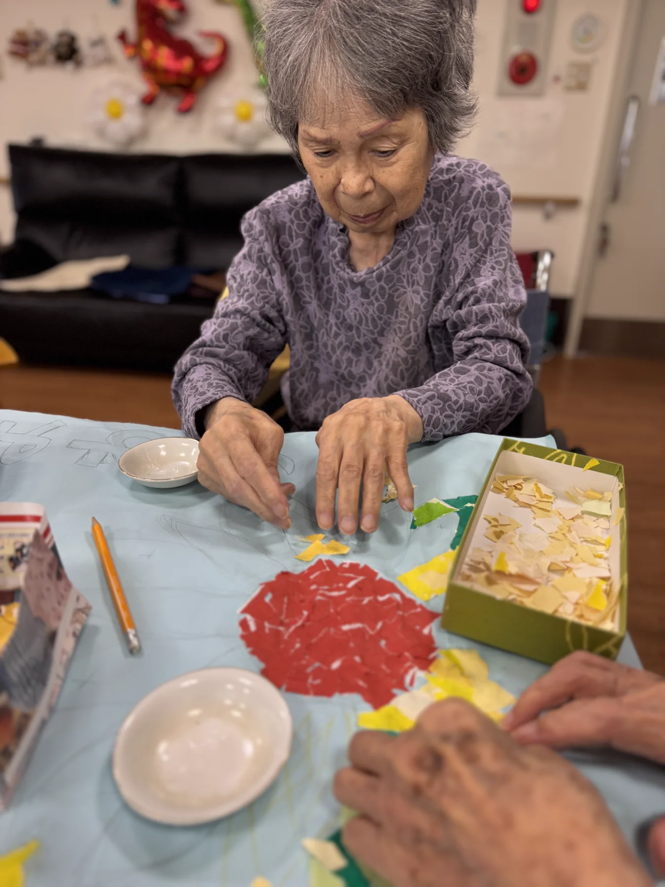 テーブルで貼り絵に取り組む入居者