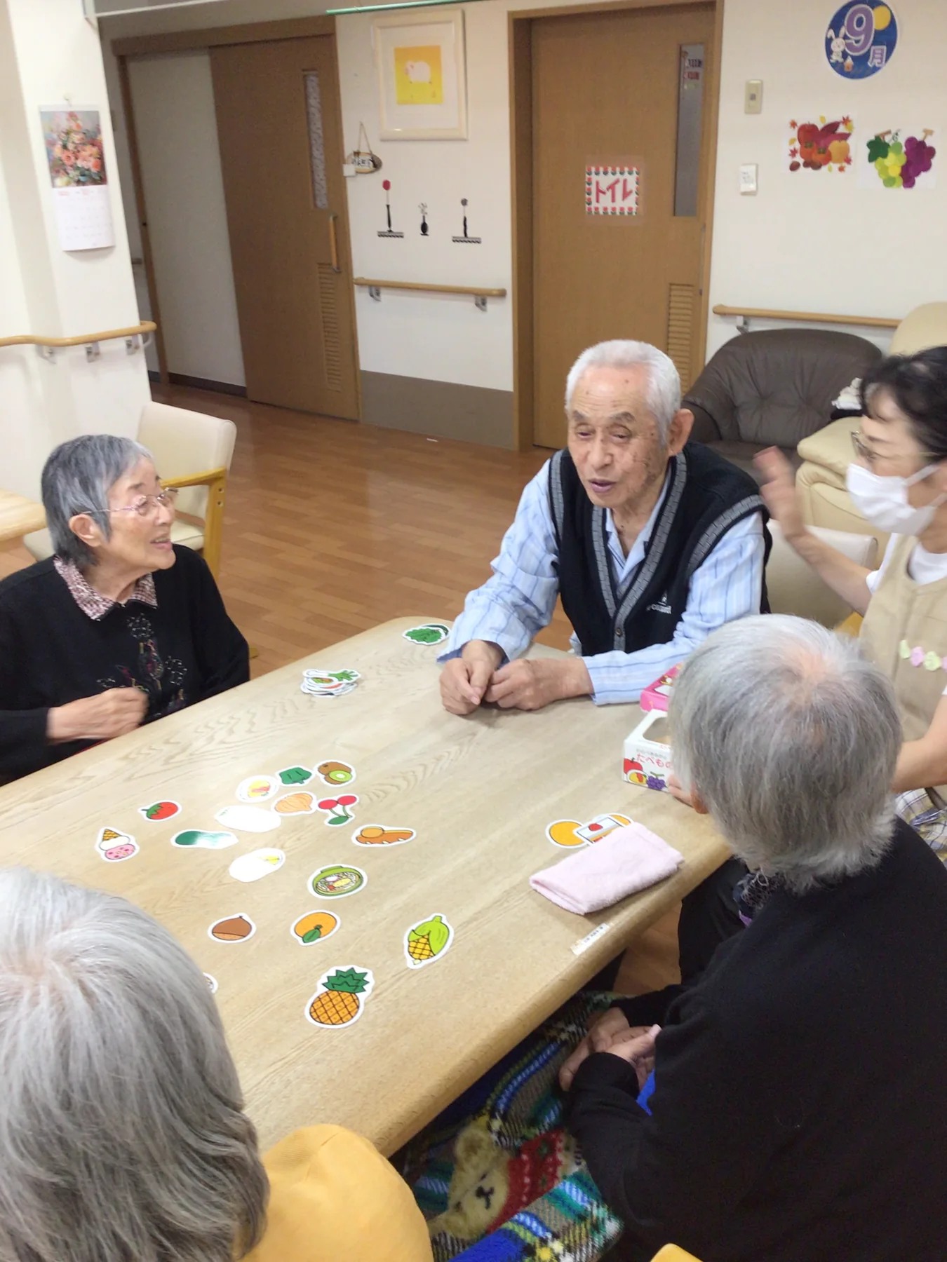 入居者と職員がテーブルを囲んでゲームを楽しむ様子