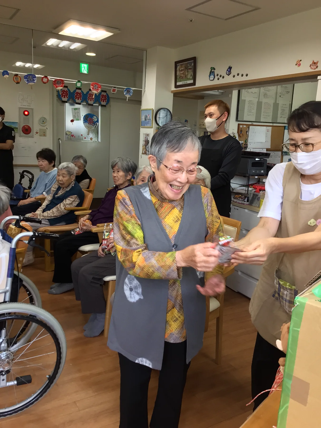 夏祭りで職員から景品を受け取る入居者