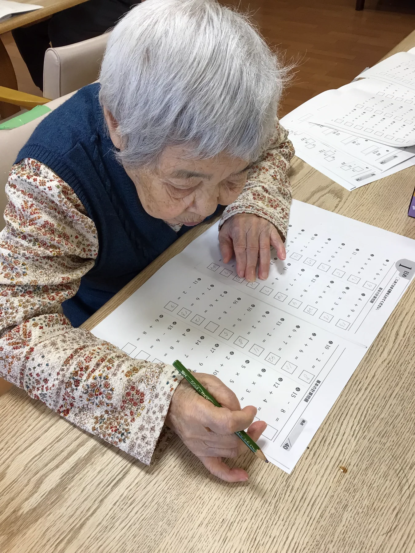 テーブルで計算問題に取り組む入居者