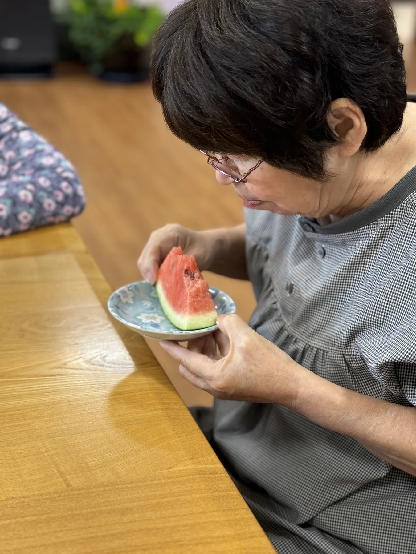 入居者が室内でスイカを味わう様子