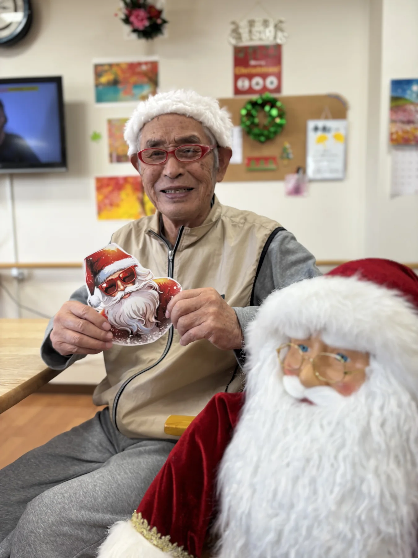 クリスマスの飾りを手に笑顔を見せる入居者