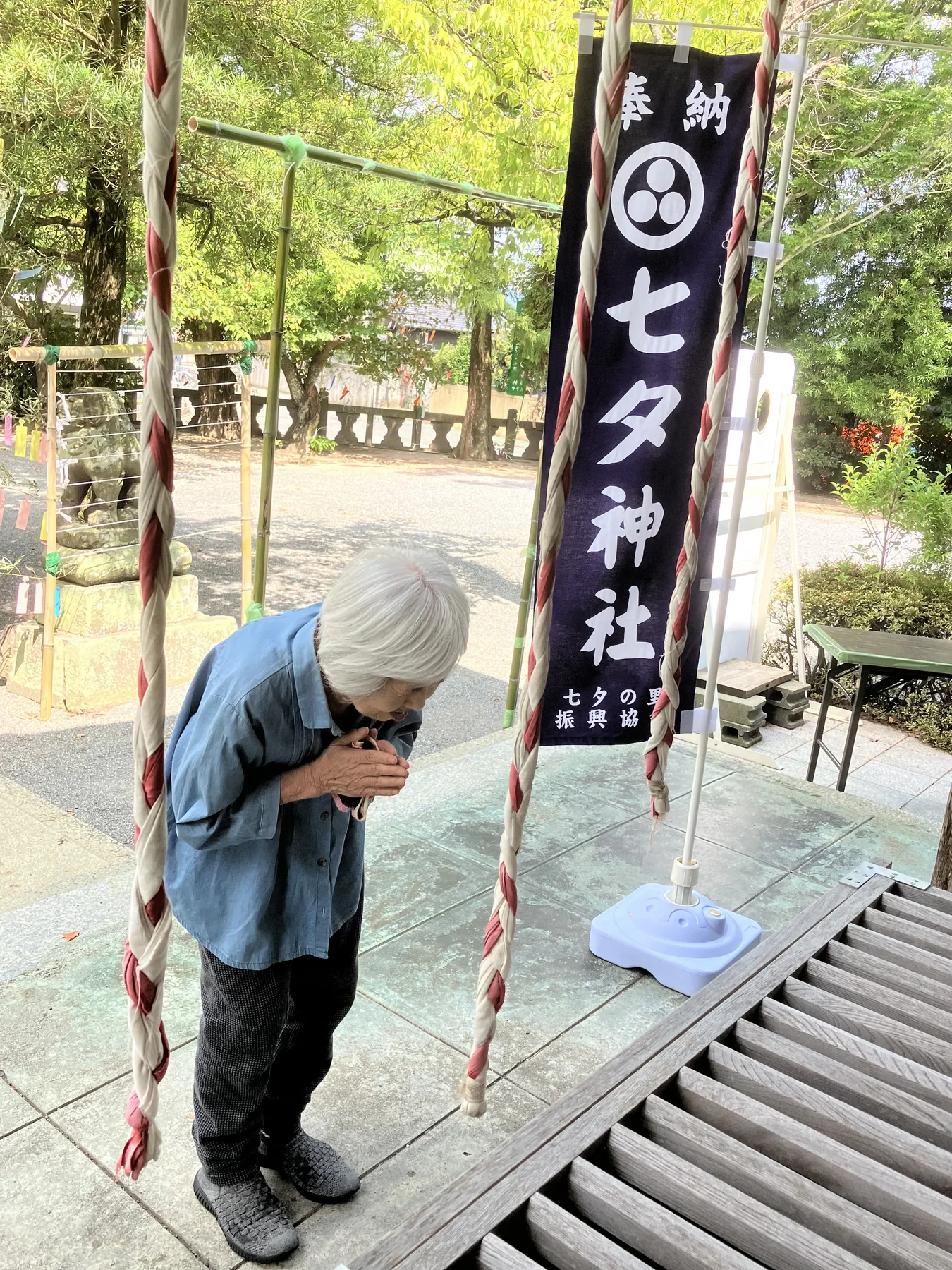 七夕飾りのある神社で参拝する入居者